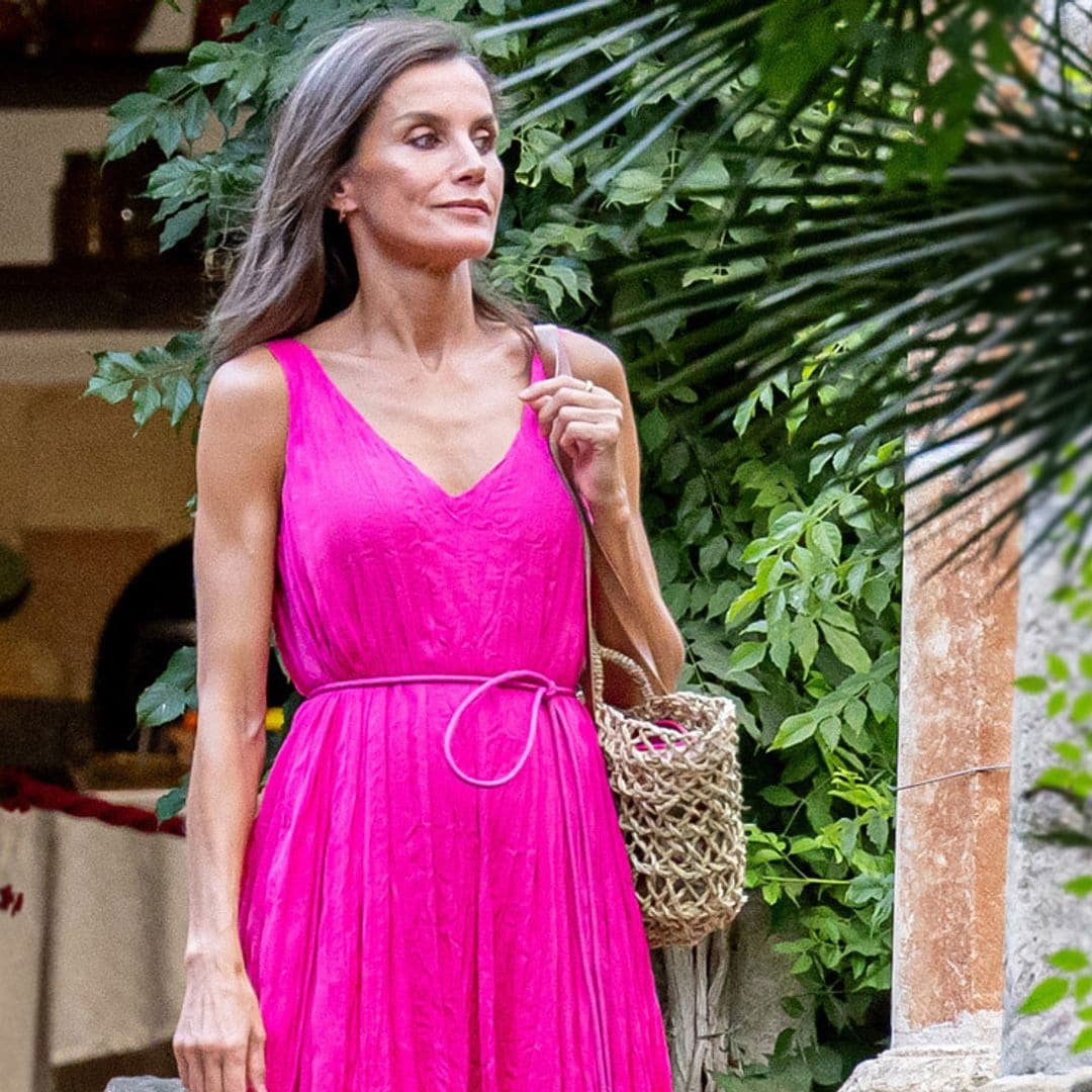 La reina Letizia posa en familia con un vestido fucsia de acabado arrugado y complementos rústicos