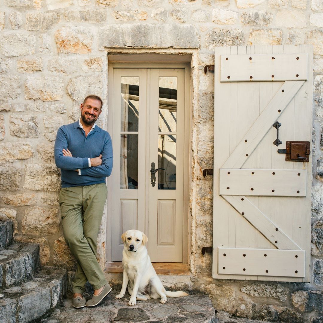 Toto Bergamo con su perro posando en la fachada de su casa