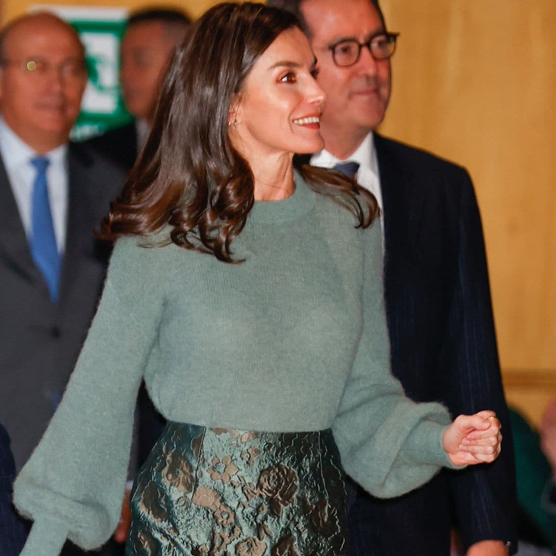 La Reina recicla su look de invitada más versátil: jersey calentito y falda brocada de flores