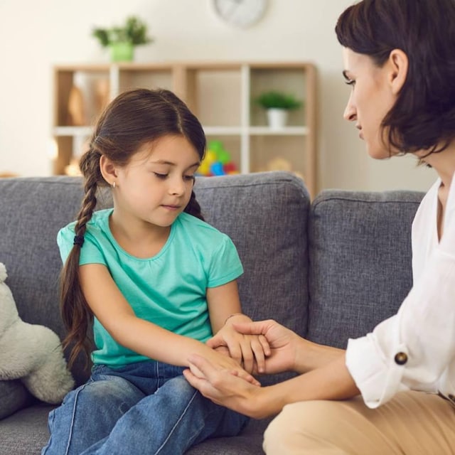 madre hablando con su hija mientras le coge las manos