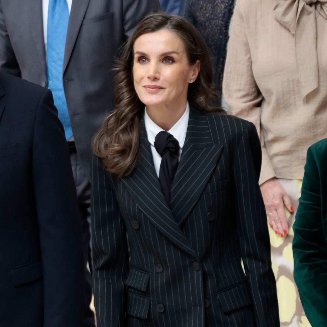 La reina Letizia cambia de registro en Oviedo con un traje masculino de raya diplomática y pañuelo como corbata