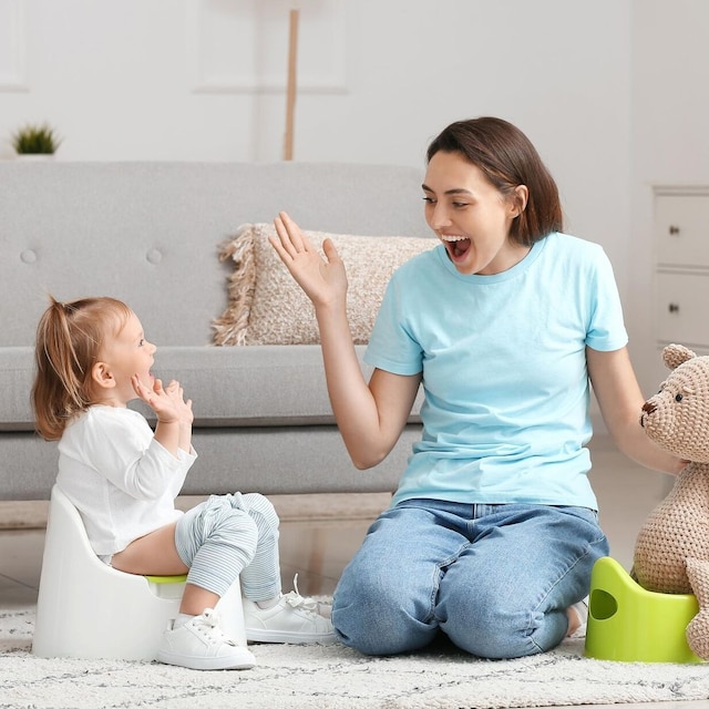 mam con su hija sentada en el orinal