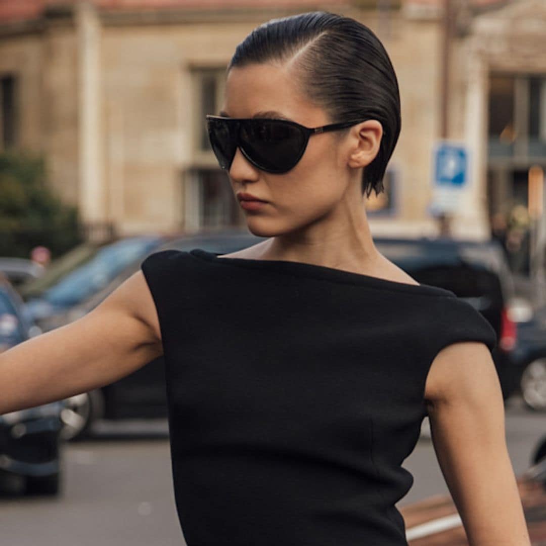 Look de fiesta con vestido negro, gafas y peinado efecto wet