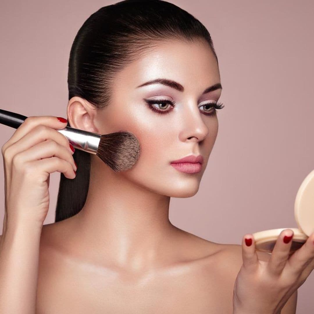 mujer aplica maquillaje en sus mejillas