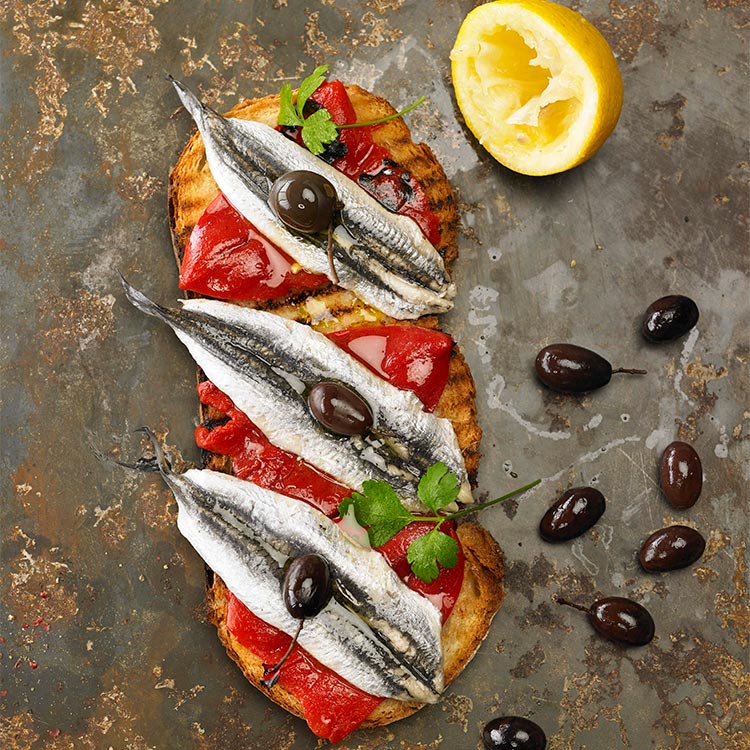 Entrantes junto con una ensalada de boquerones en vinagre.  Tostas-pimientos-age-z