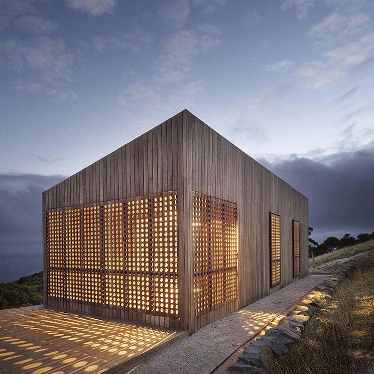 Una casa de madera bajo las estrellas concebida como una caja de luz