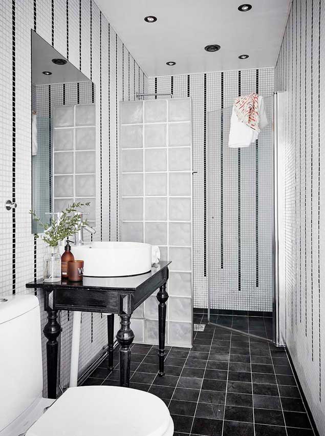 Baño de inspiración nórdica con ducha y mueble antiguo en el lavabo