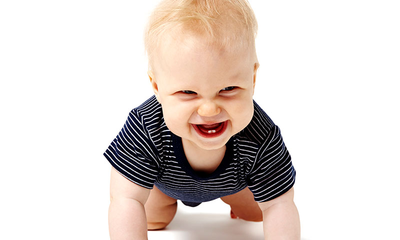 Bebe sonriendo y mostrando dos primeros dientes