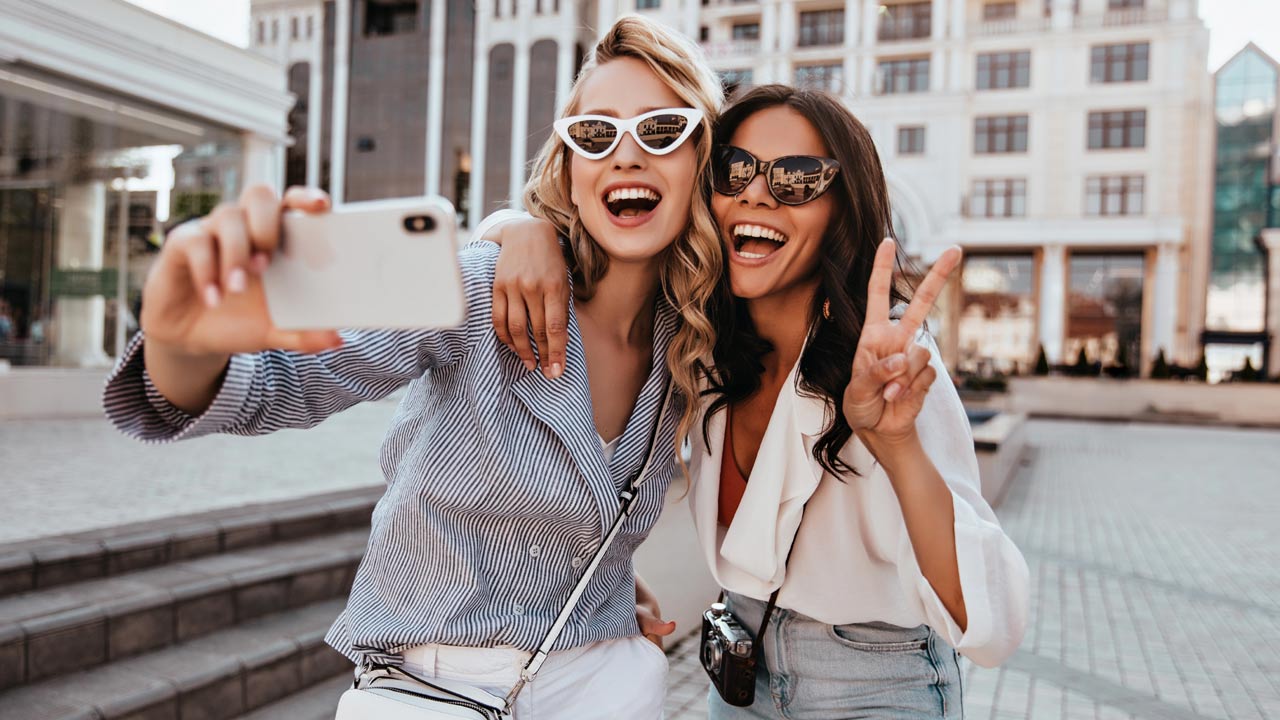mujeres sonrientes haciéndose un selfie