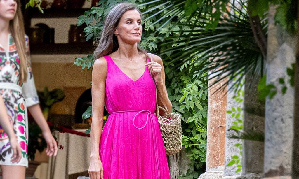 La reina Letizia posa en familia con un vestido fucsia de acabado arrugado y complementos rústicos