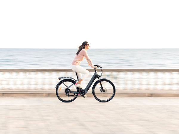Mujer paseando en bicicleta eléctrica de Moma Bikes