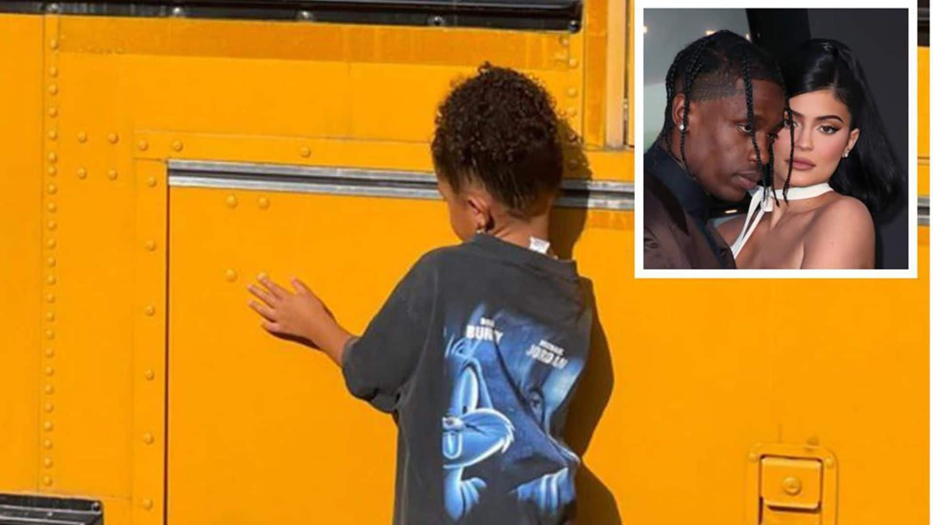 Stormi Webster pretends to ride in a yellow school bus