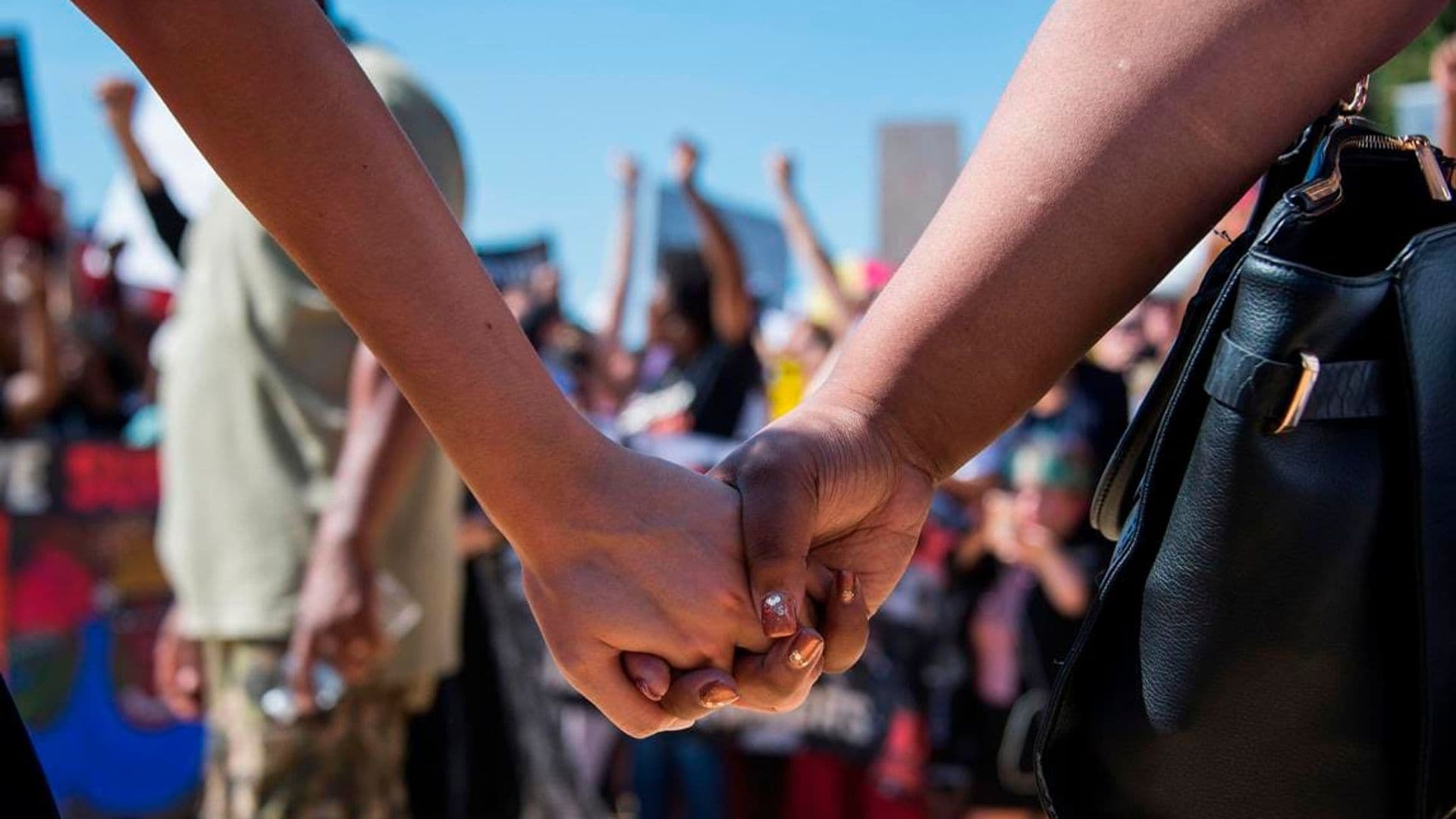 Two women hold hands