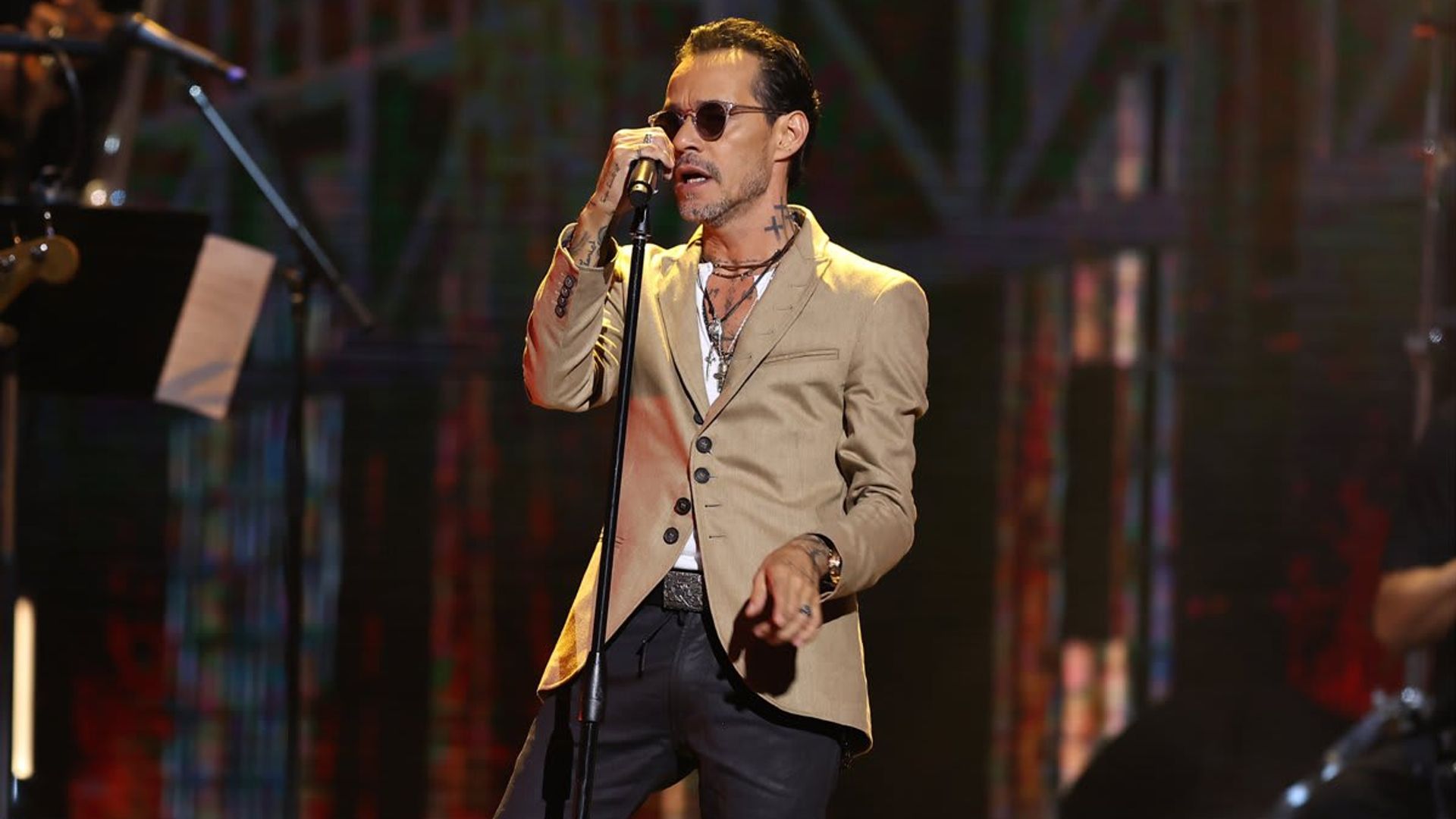 Marc Anthony helps a fan pop the question on stage during concert