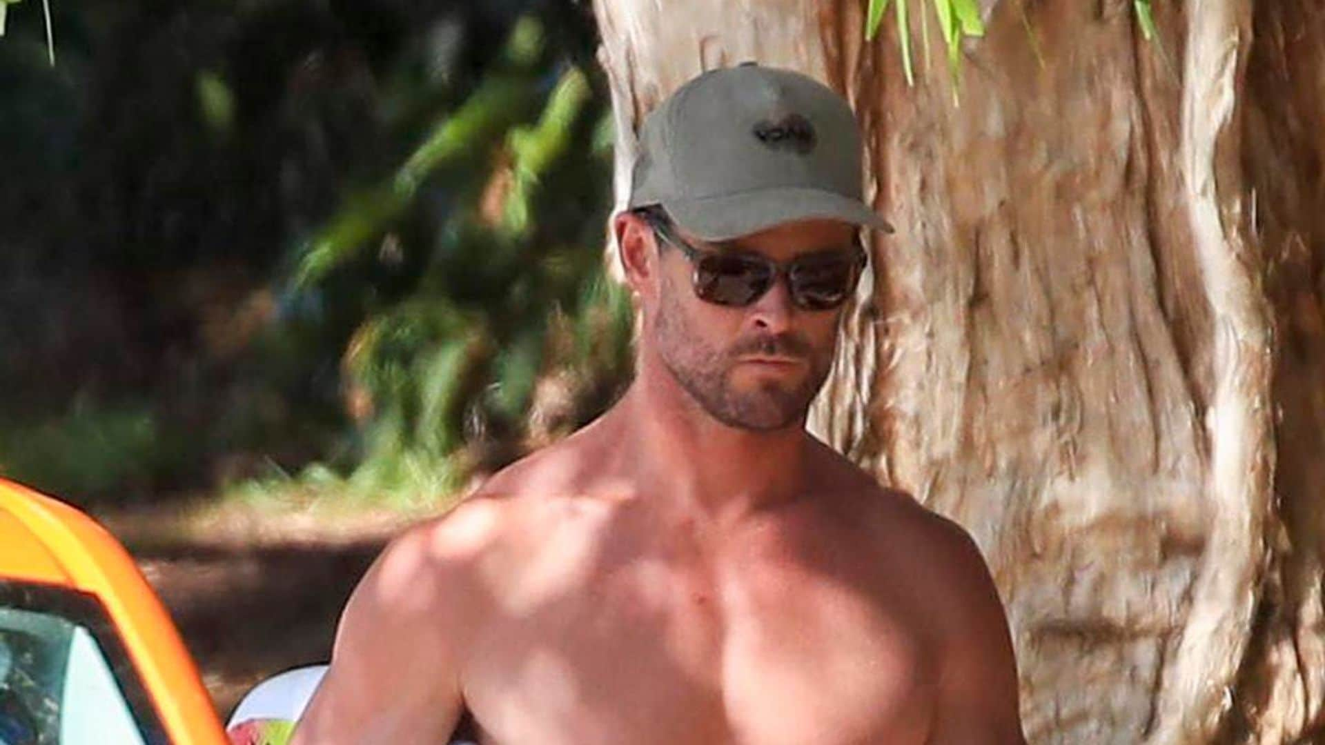 Chris Hemsworth flaunts his muscular physique while surfing at a Byron Bay beach