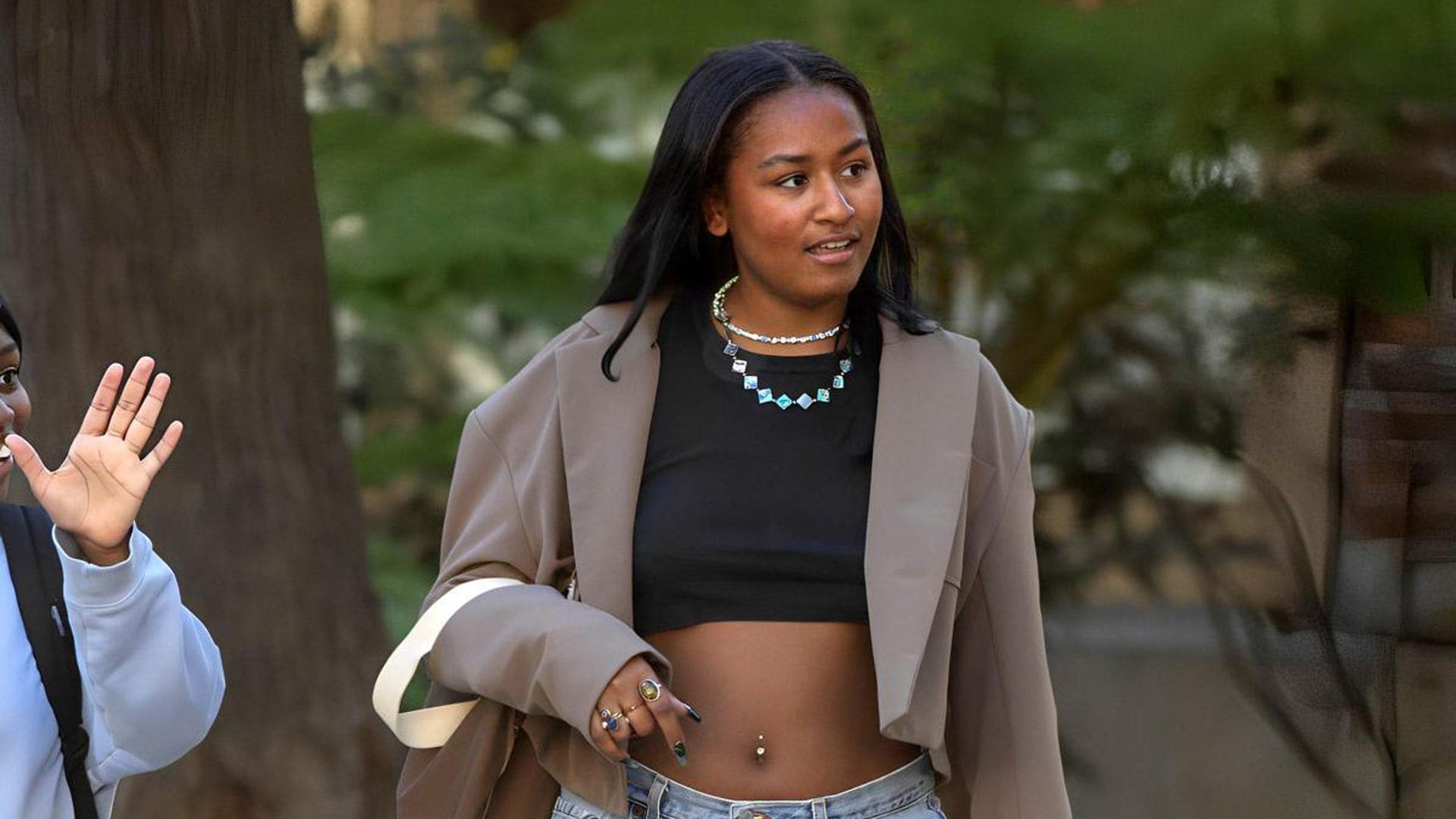 Sasha Obama shows her belly button piercing while wearing a trendy black crop top outfit