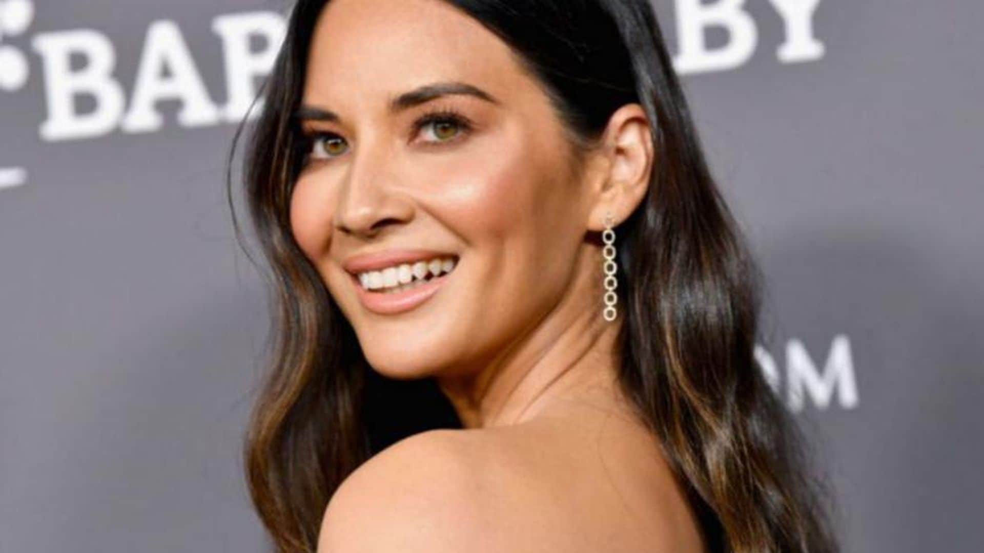 Olivia Munn with loose wavy hair and a brown dress