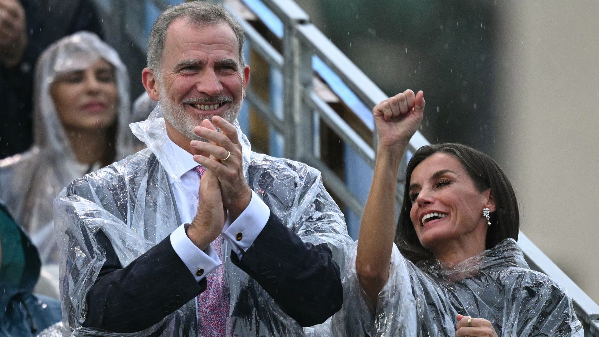Queen Letizia and King Felipe keep dry in ponchos at Paris Olympics Opening Ceremony