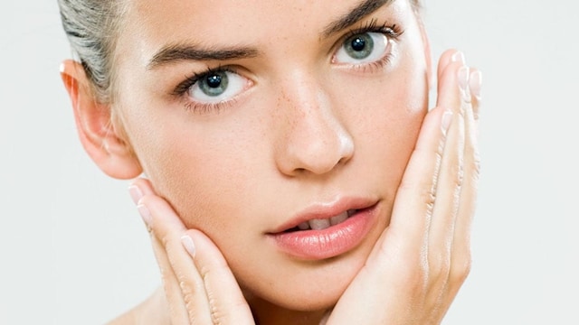 A young woman performing skincare