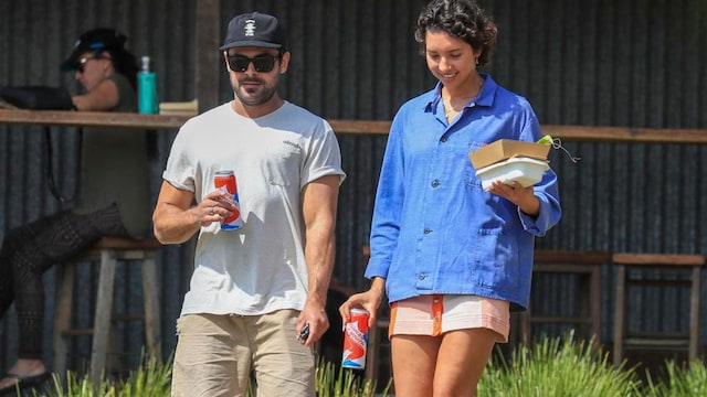 Zac Efron in white shirt and hats holds hand with Vanessa Valladares on a lunch outing in Byron Bay.