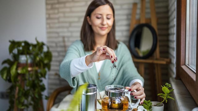 Young Woman preparing her winter tea and welcoming new day