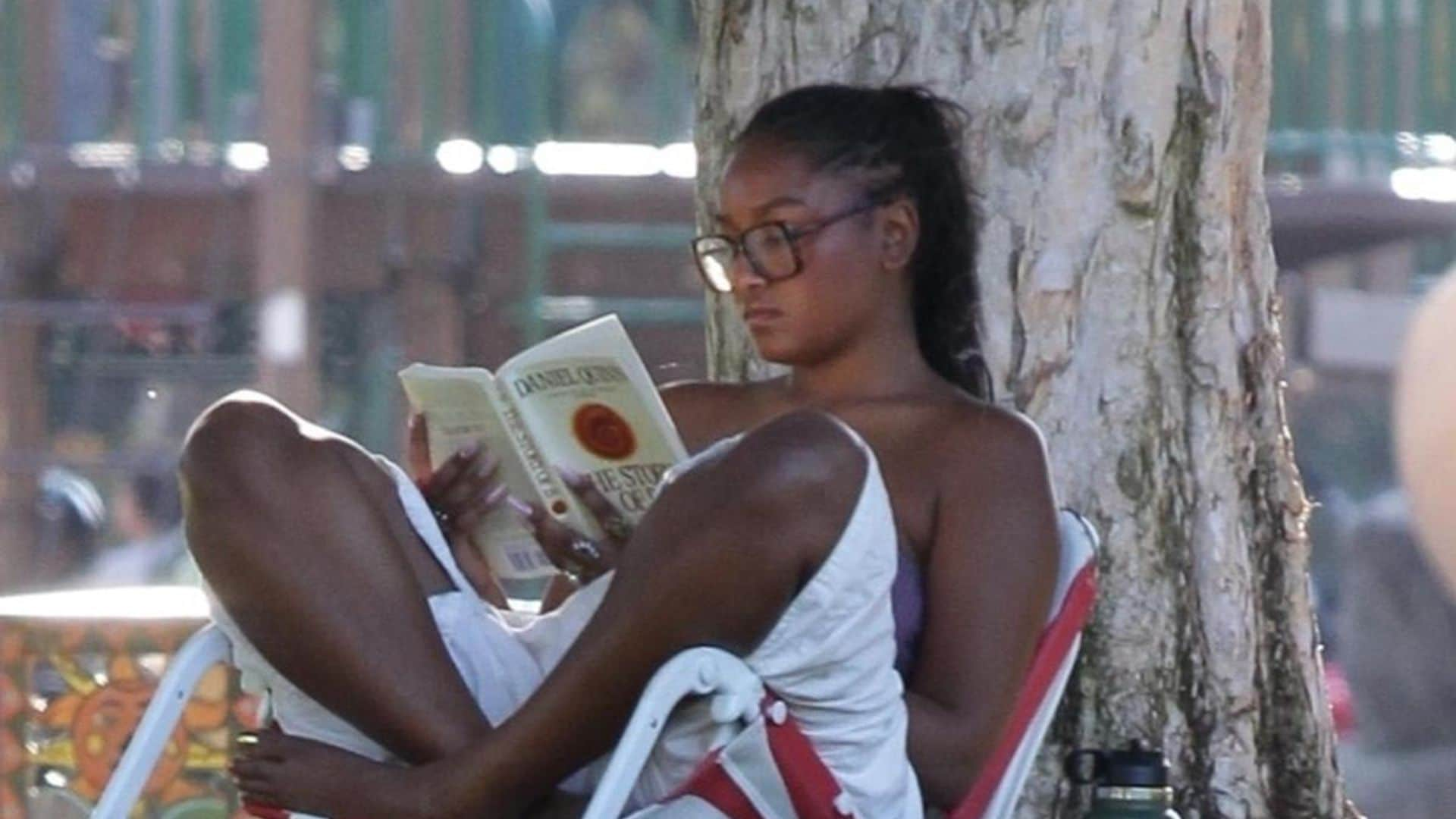 Sasha Obama relaxes under a tree while reading a philosophical novel