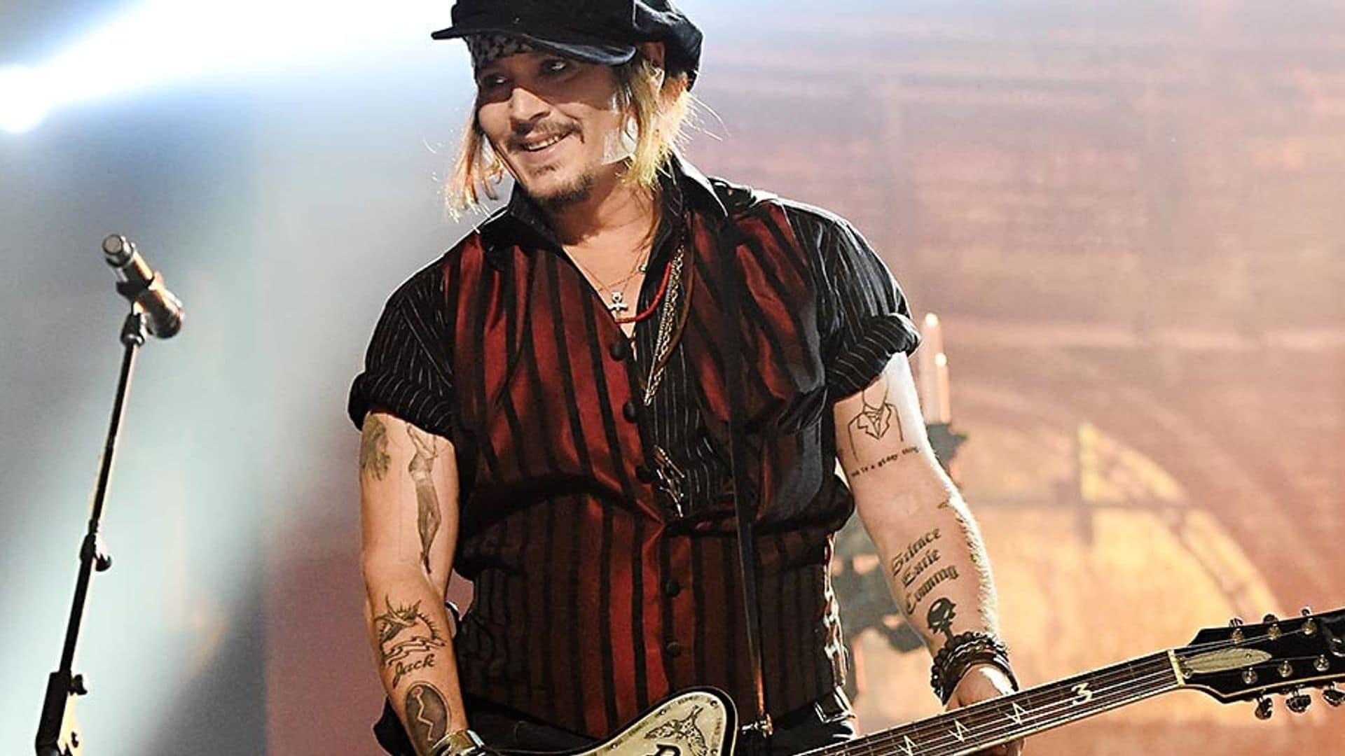 Johnny Depp playing guitar on stage