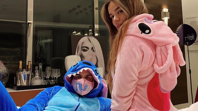 Anuel AA and Karol G wearing Disney onesies