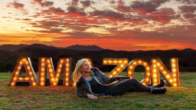 Jessica Simpson posing in front of Amazon sign