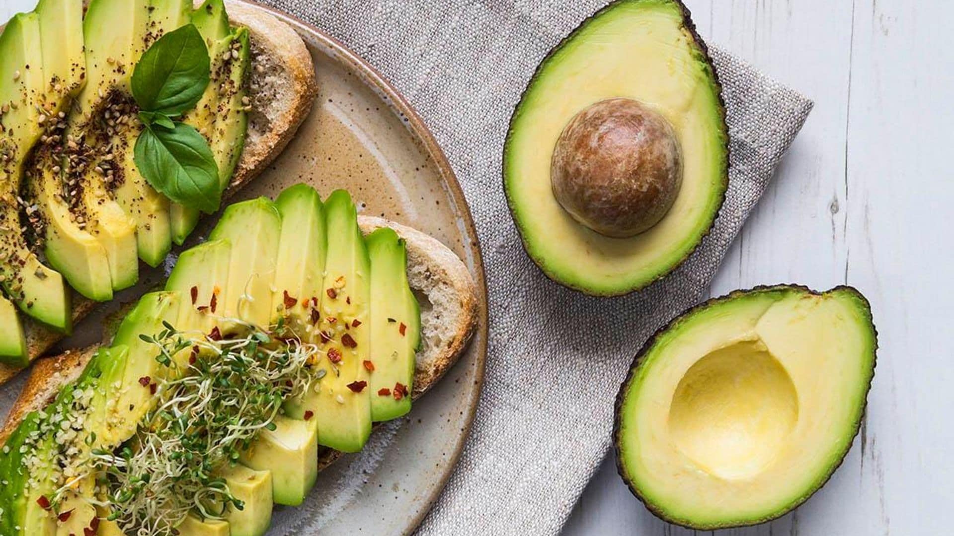 A delicious plate of avocado toast topped with basil and seasoning.