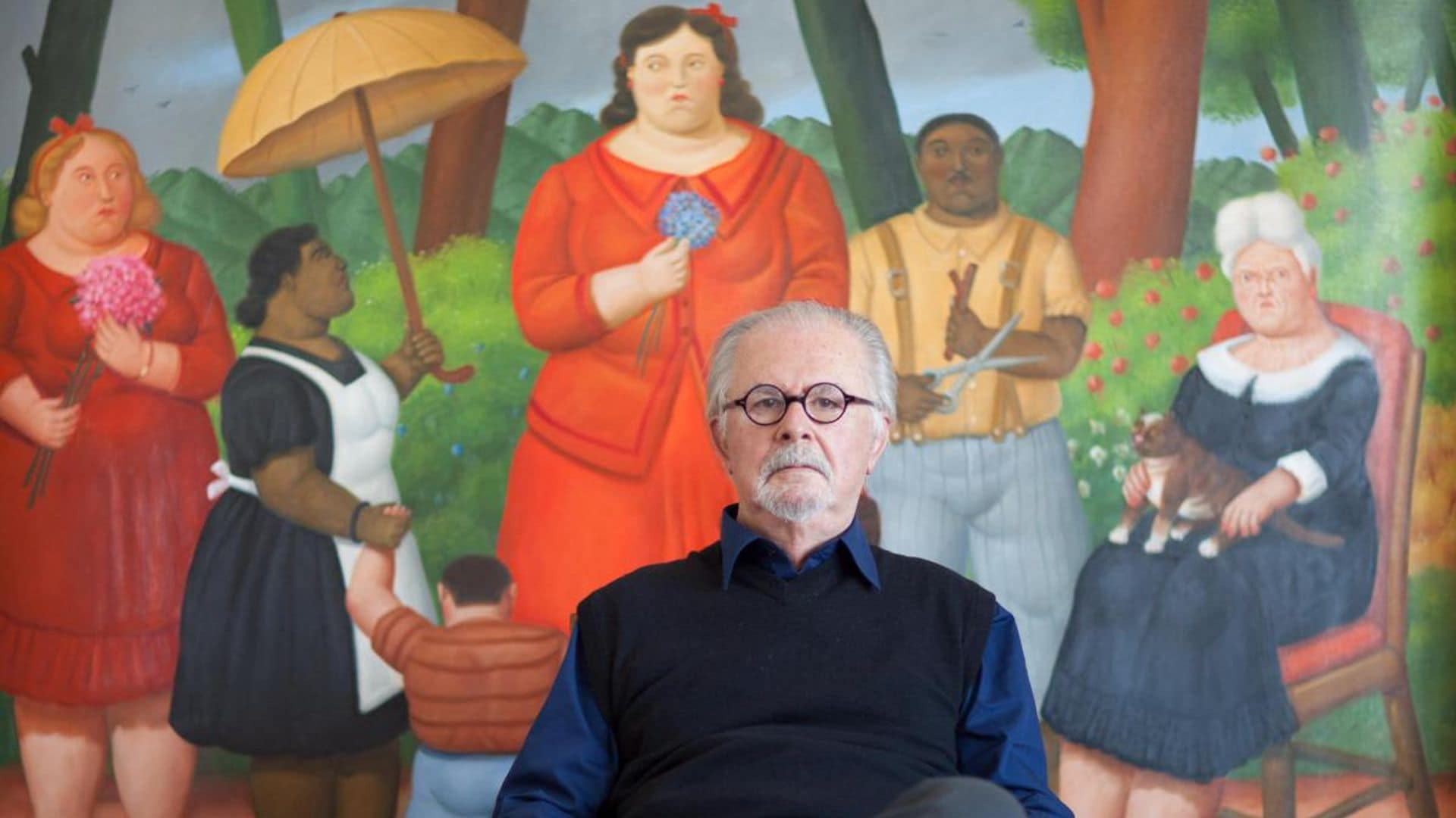 Fernando Botero sitting at his studio in front of a painting