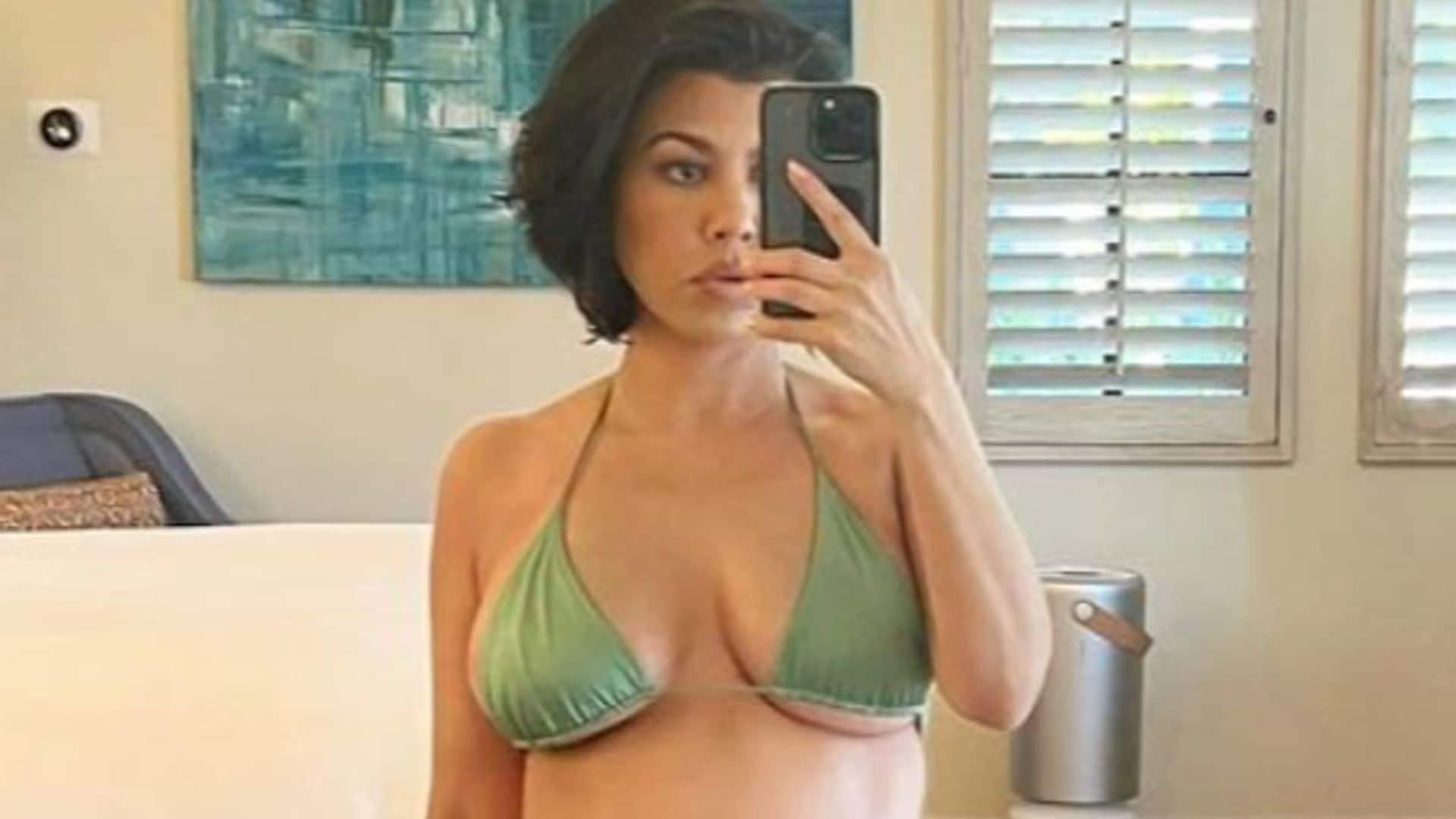 Kourtney Kardashian poses poolside showing off her baby bump