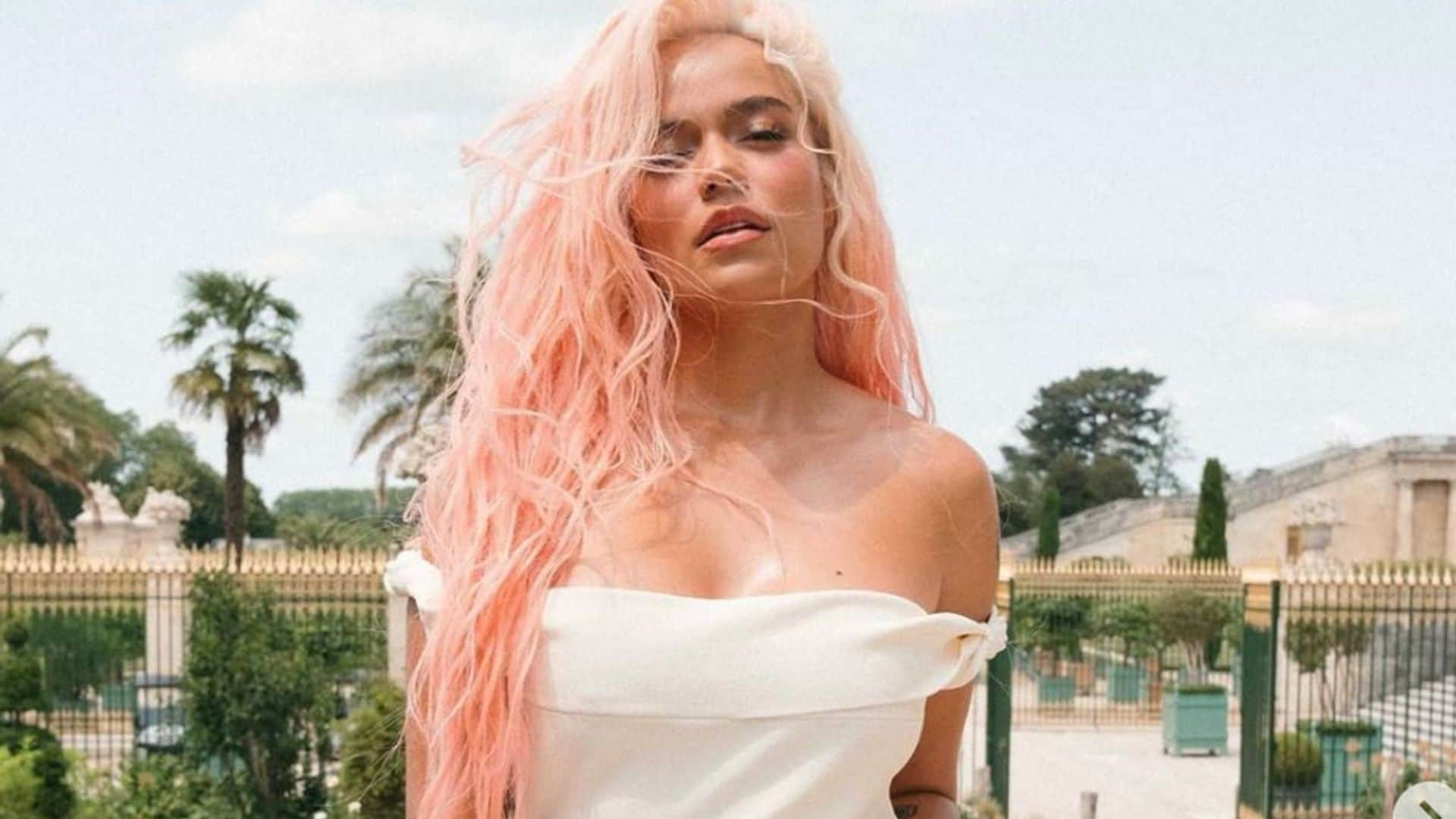 Karol G shows off her curves wearing nothing but a hair bow and long pink hair