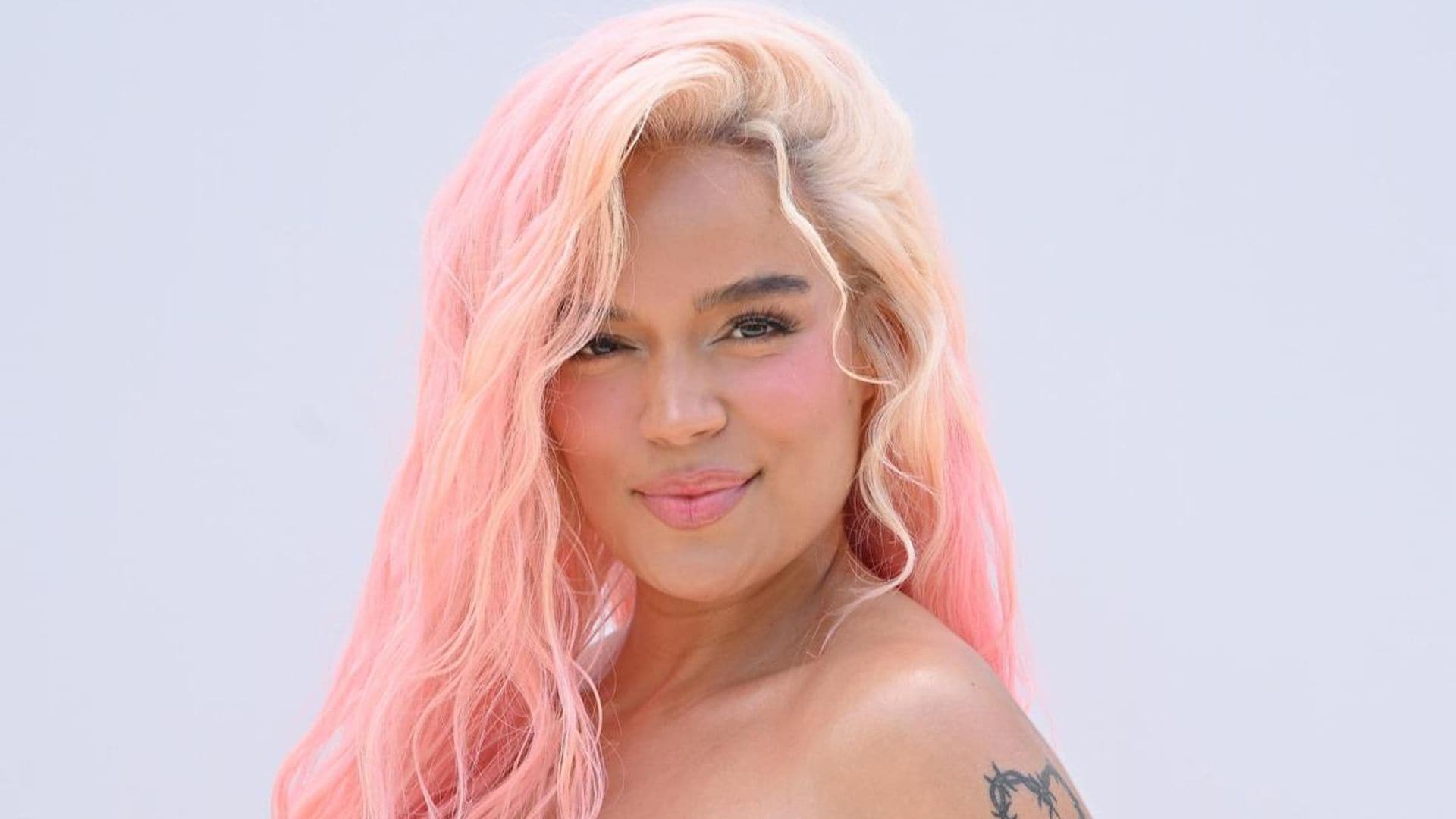 Karol G stuns in an off-the-shoulder gown and ombré pink hair at Jacquemus’ fashion show
