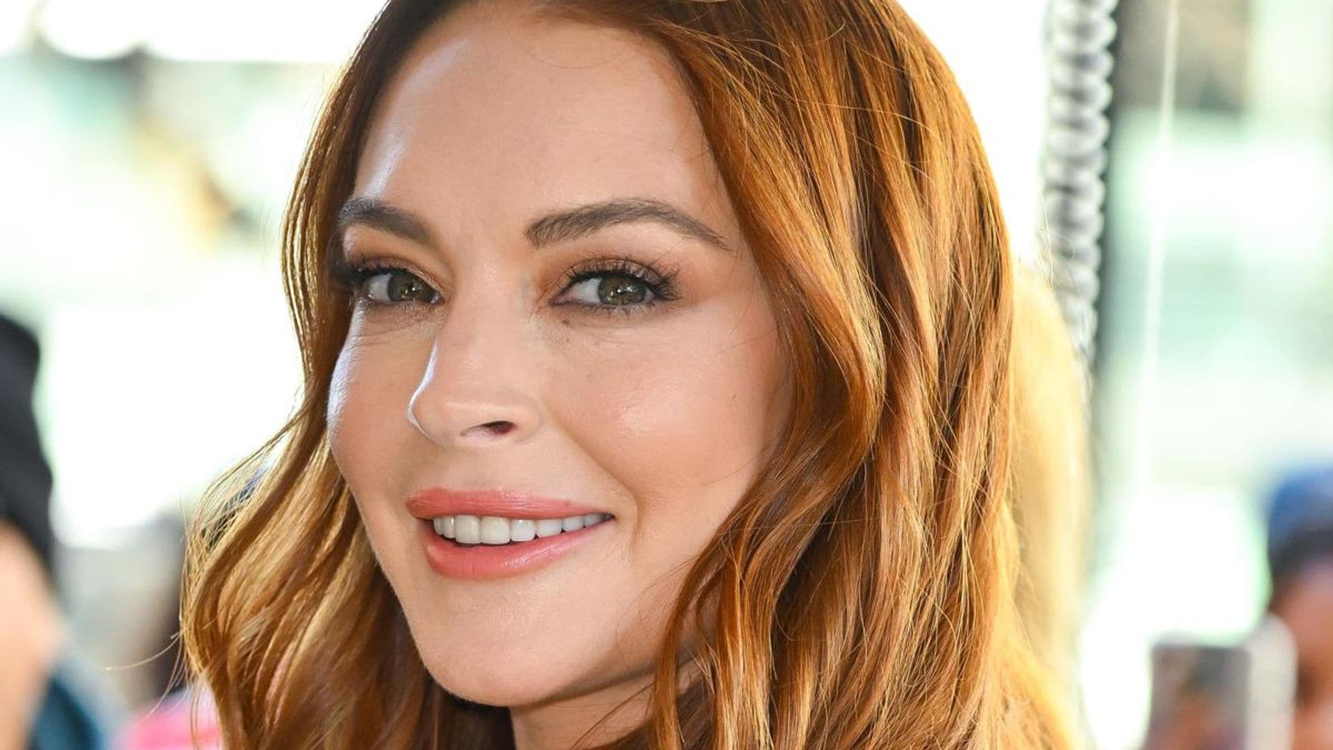 Lindsay Lohan and her growing baby bump pose in a black swimsuit