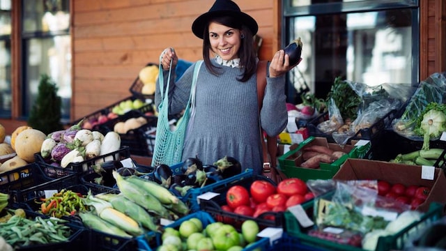 Smiling young woman shopping vegetables.