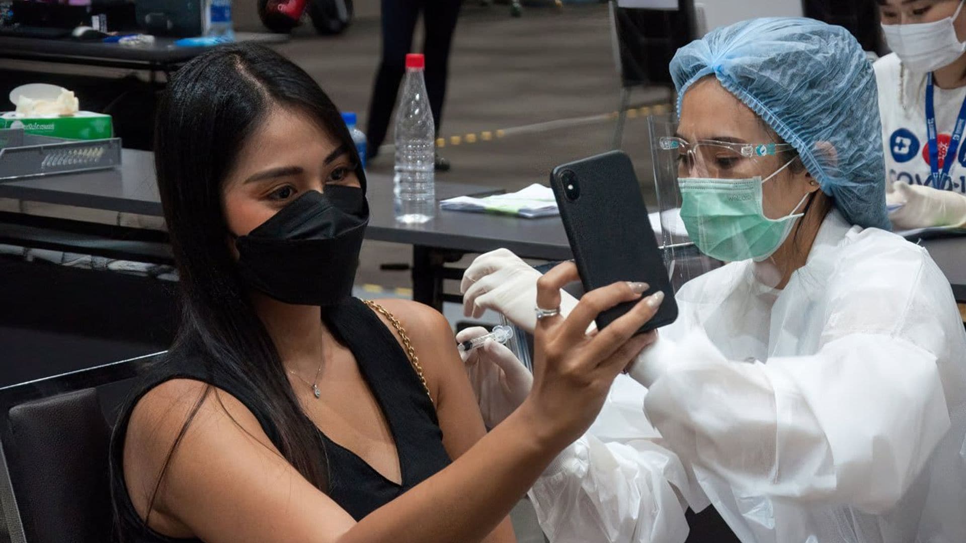 A woman takes a selfie of herself while being administered