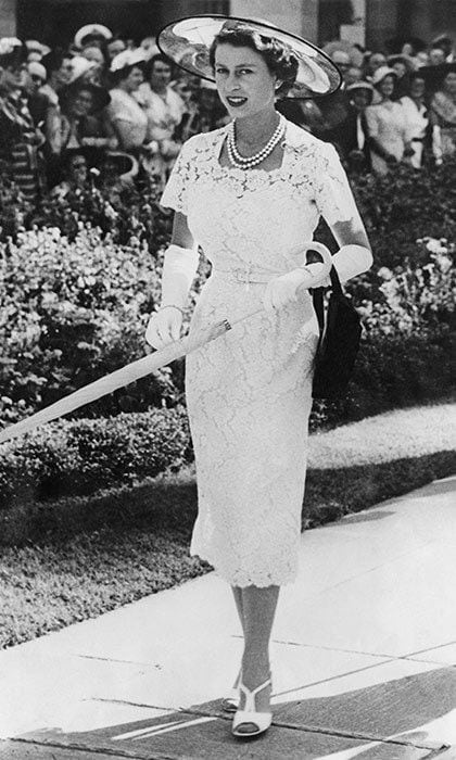 Queen Elizabeth wore a slim-fitting white lace dress to a garden party in Sydney, Australia, before leaving for Tasmania on the liner 'SS Gothic' in 1954.
<br>
Photo: Getty Images