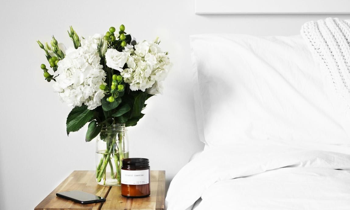 Bed with white linens and flowers