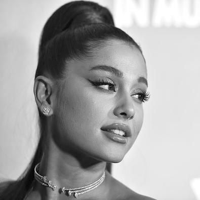 Ariana Grande in black and white, with a ponytail, cat eye liner, and lash extensions