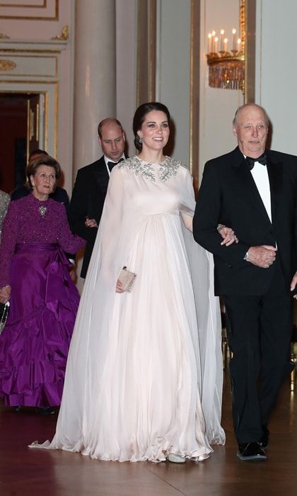 Kate made sure to stun on her last royal tour before welcoming baby number three in April 2018. The Duchess, who was escorted into a dinner at the royal palace in Oslo by Norway's King Harald, was mesmerizing in a blush Alexander McQueen gown. The dress featured a sheer cape and a diamond-encrusted pattern at the shoulders. To complement the look, she wore her hair in an elegant updo and accessorized with drop earrings and a bracelet Queen Elizabeth wore on her wedding day.
Photo: Getty Images