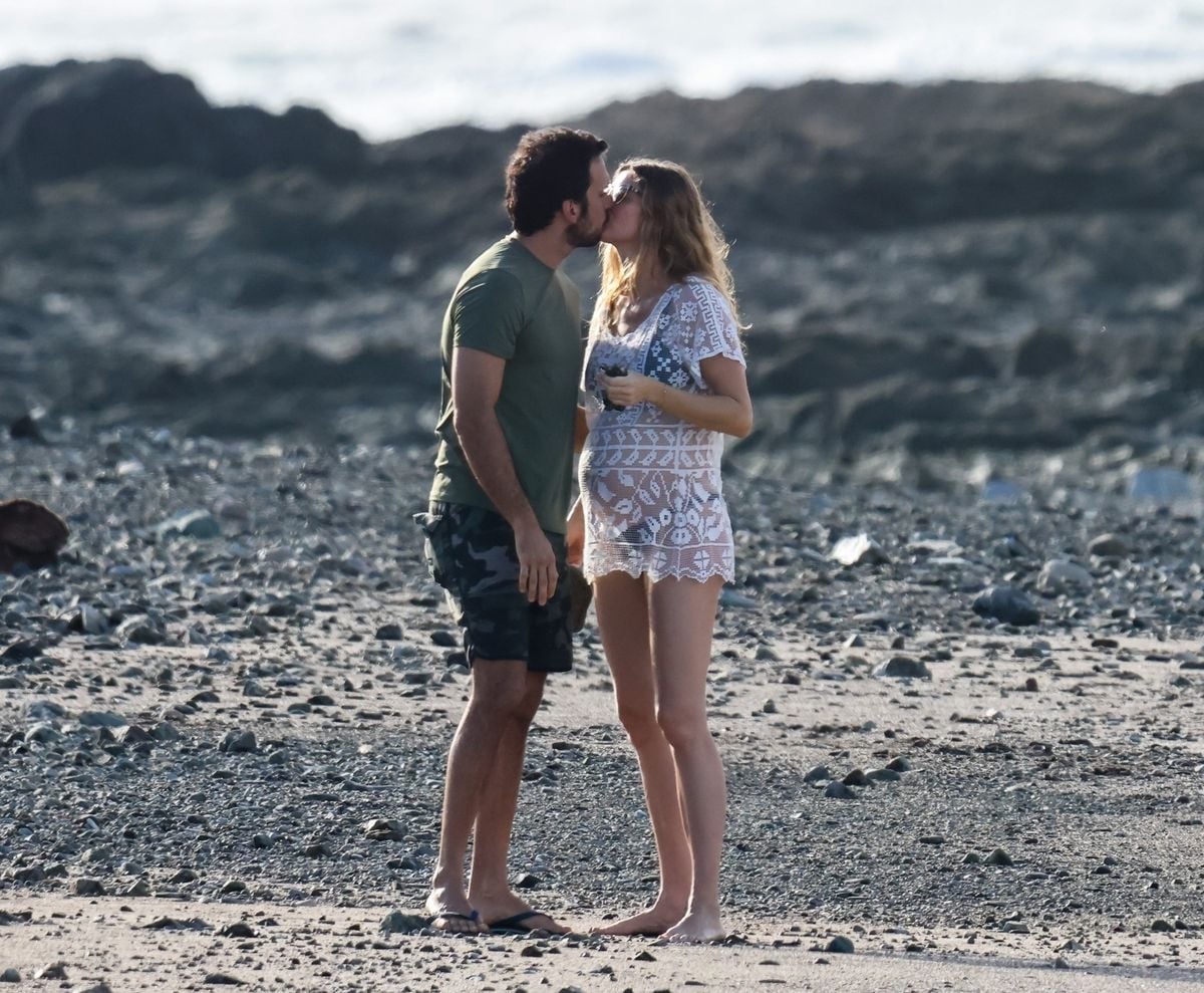 Pregnant Gisele Bündchen and soon-to-be new dad Joaquim Valente walked hand-in-hand along a quiet beach in Costa Rica. Gisele, showing her baby bump and glow,  smiled happily as they strolled by the ocean. They stopped to kiss, enjoying the peaceful moment together.