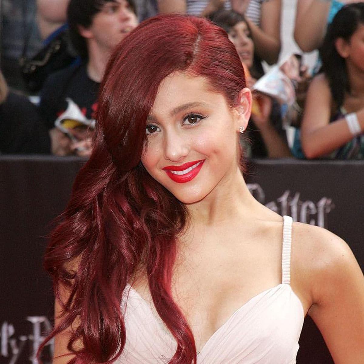 Ariana Grande con cabello rojo, largo y con rizos