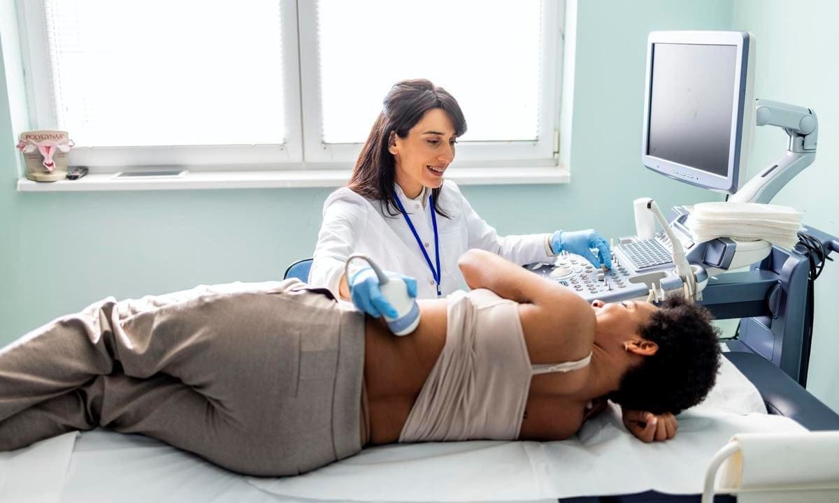 Doctor checking woman back during sonography procedure