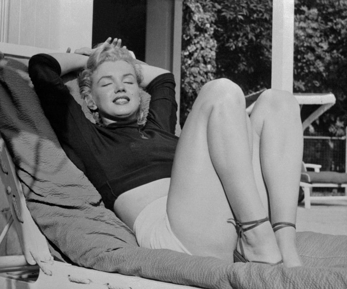 Hollywood film star Marilyn Monroe relaxes on her terrace, looking beautifully content. 