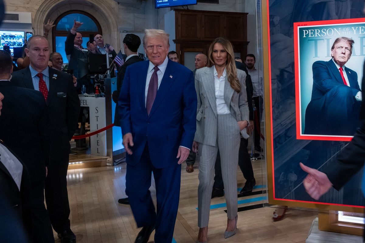 Donald Trump walks onto the floor of the New York Stock Exchange with his wife Melania