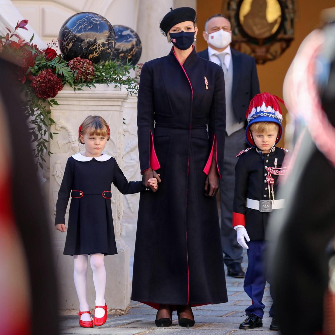 Princess Charlene exuded elegance in a sleek navy coat that featured red lining and a beret.