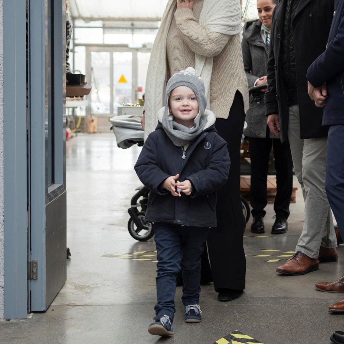 Big brother Charles bundled up in a jacket teamed with a grey beanie featuring snowflakes.