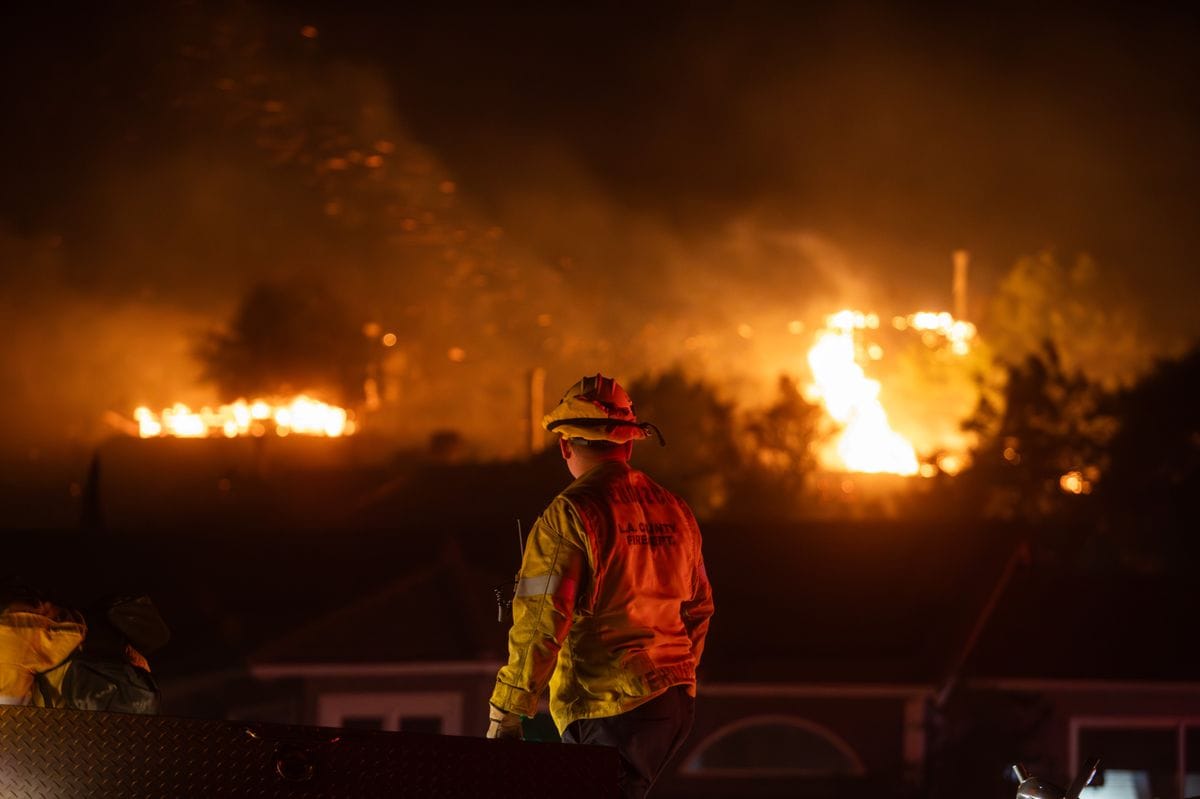 A Firefighter monitor a mountainside as the Franklin Fire burns at night on December 10, 2024 near Malibu, California. 