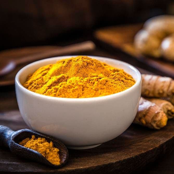 Bowl with turmeric power and various roots